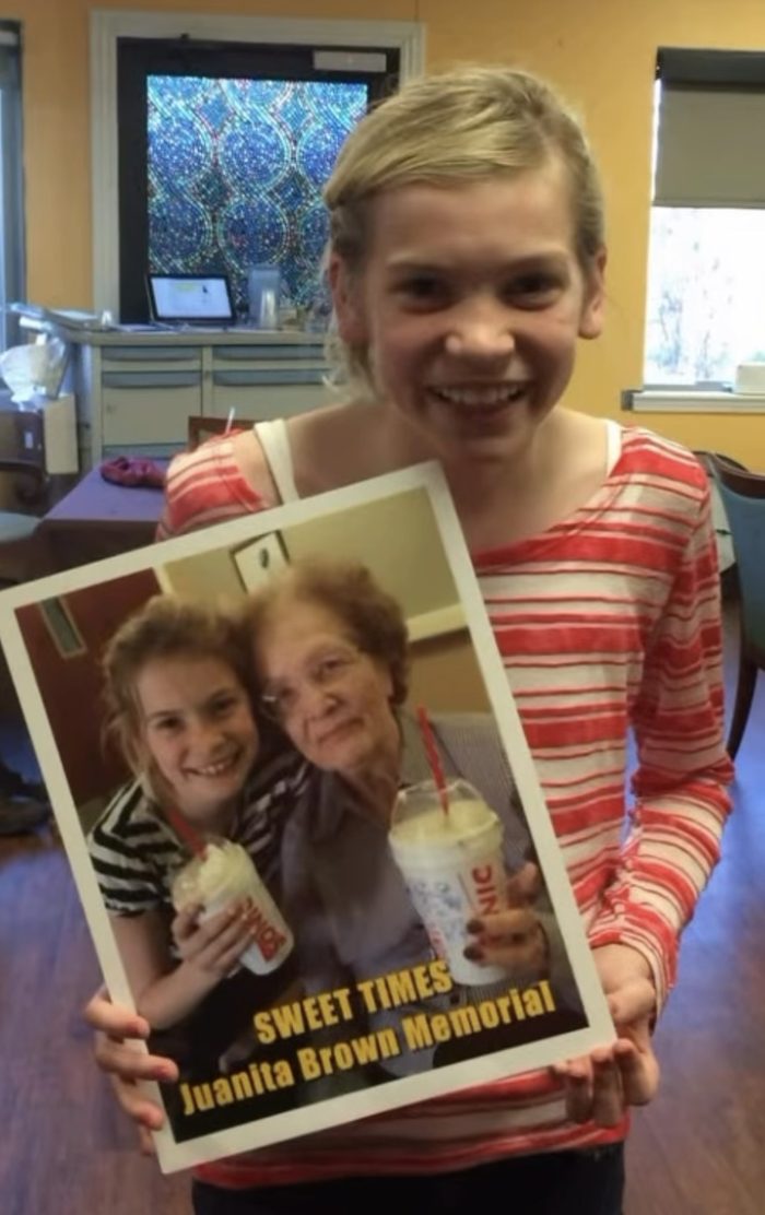 A young Anna Claire Hay holding a Sweet Times photo from the Juanita Brown Memorial